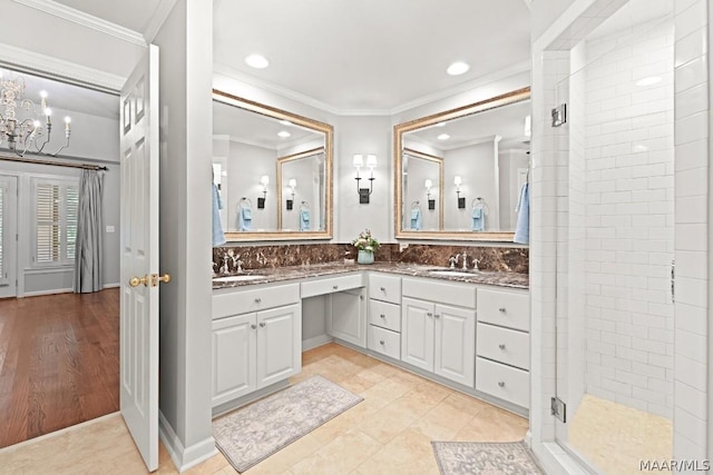 bathroom featuring vanity, tile patterned floors, decorative backsplash, ornamental molding, and an enclosed shower