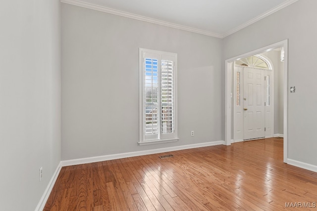 empty room featuring light hardwood / wood-style flooring and ornamental molding