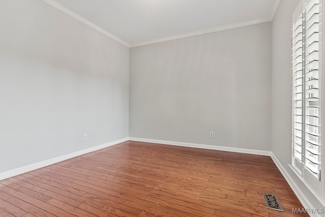 empty room featuring hardwood / wood-style floors and ornamental molding