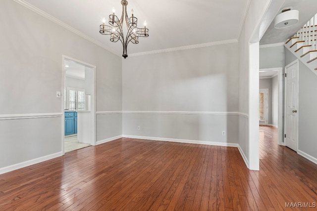 empty room featuring wood-type flooring, an inviting chandelier, and ornamental molding