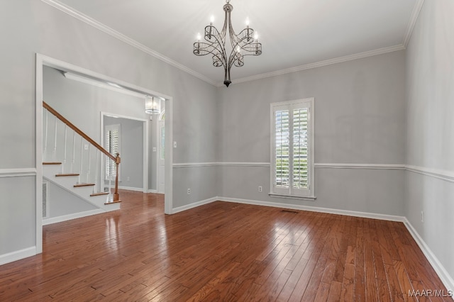 unfurnished room with ornamental molding, wood-type flooring, and an inviting chandelier