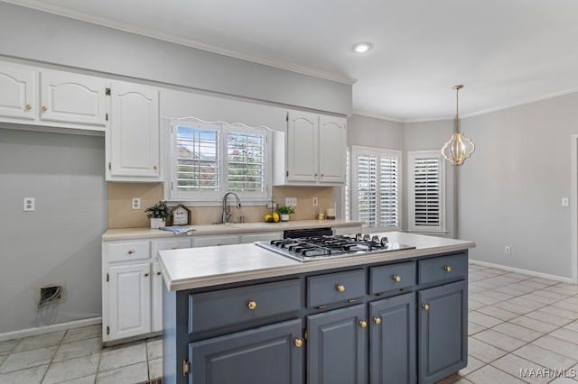 kitchen with pendant lighting, stainless steel gas stovetop, light tile patterned floors, a center island, and white cabinets