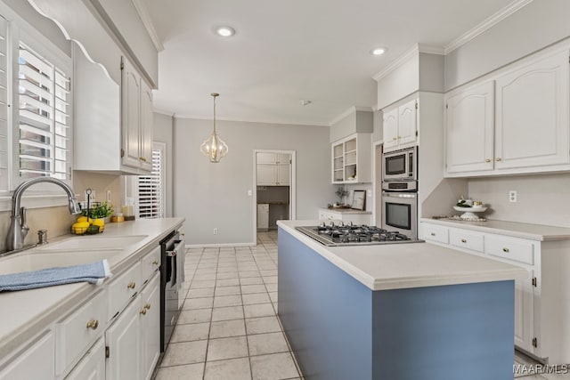 kitchen featuring decorative light fixtures, appliances with stainless steel finishes, white cabinetry, sink, and a kitchen island