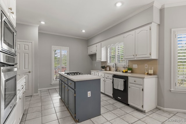 kitchen with appliances with stainless steel finishes, a wealth of natural light, and white cabinetry