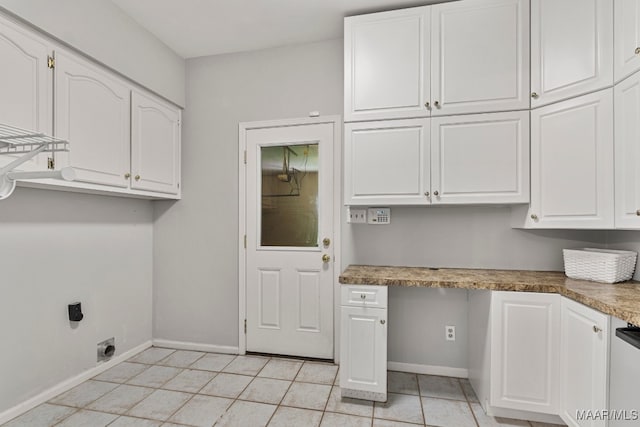 interior space with cabinets, light tile patterned floors, and electric dryer hookup