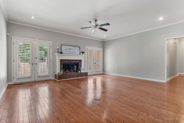 unfurnished living room with a fireplace, light hardwood / wood-style flooring, french doors, ornamental molding, and ceiling fan