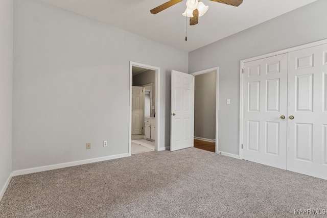 unfurnished bedroom with a closet, ceiling fan, light colored carpet, and ensuite bath