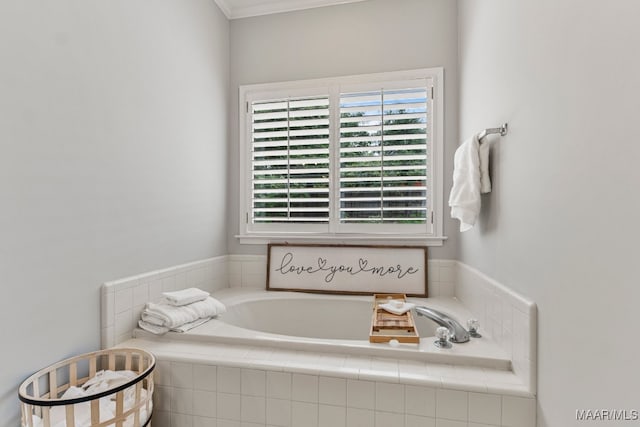 bathroom with ornamental molding, plenty of natural light, and a relaxing tiled tub