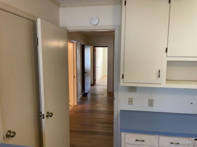 hall with dark hardwood / wood-style floors and ornamental molding