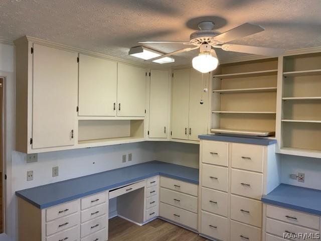 unfurnished office with ceiling fan, dark hardwood / wood-style floors, and a textured ceiling