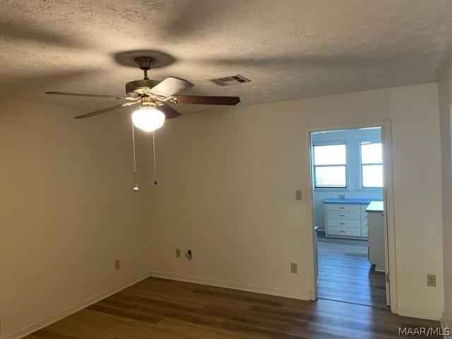 unfurnished room featuring a textured ceiling, ceiling fan, and dark hardwood / wood-style floors