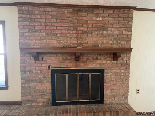 interior details featuring a brick fireplace