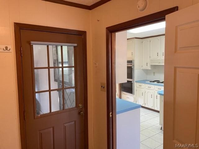 entryway featuring light tile patterned floors and ornamental molding