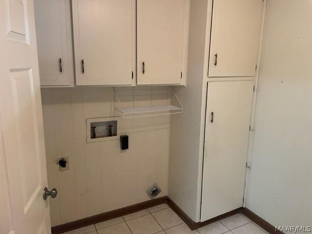 laundry area featuring electric dryer hookup, hookup for a washing machine, light tile patterned floors, and cabinets