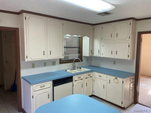 kitchen featuring white cabinets, dishwasher, light tile patterned floors, and sink