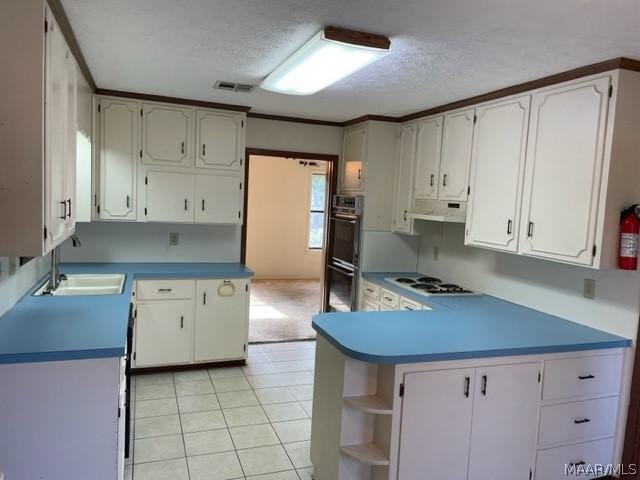 kitchen featuring a textured ceiling, white gas cooktop, sink, white cabinetry, and light tile patterned flooring