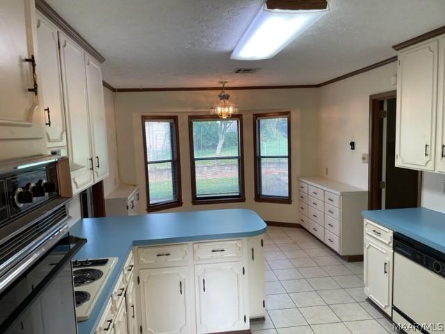 kitchen with white cabinets, a textured ceiling, white appliances, and a notable chandelier