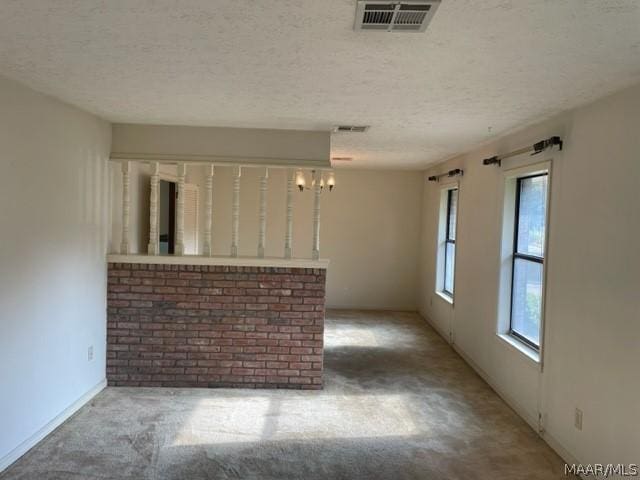 unfurnished living room featuring plenty of natural light and a textured ceiling