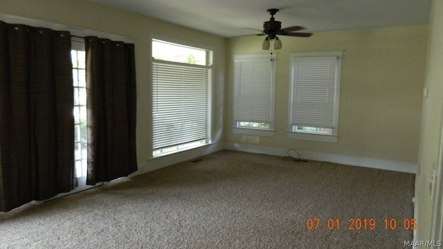 spare room featuring baseboards, ceiling fan, and carpet