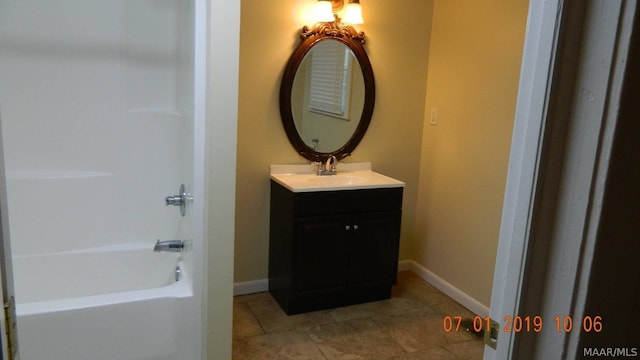 full bathroom with tile patterned flooring, bathing tub / shower combination, vanity, and baseboards