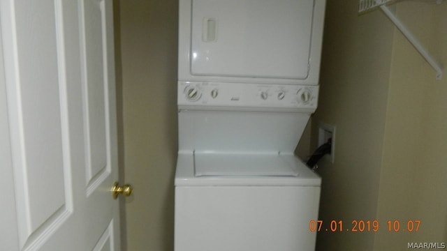 clothes washing area with stacked washer / drying machine and laundry area