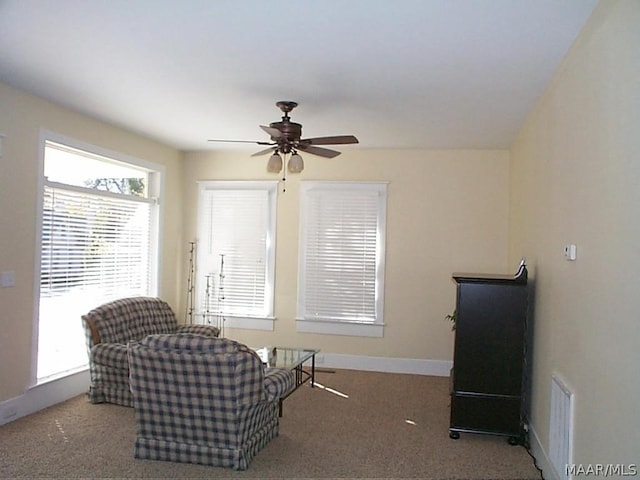 living area with carpet, ceiling fan, visible vents, and baseboards