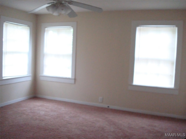 unfurnished room featuring ceiling fan, baseboards, light colored carpet, and plenty of natural light