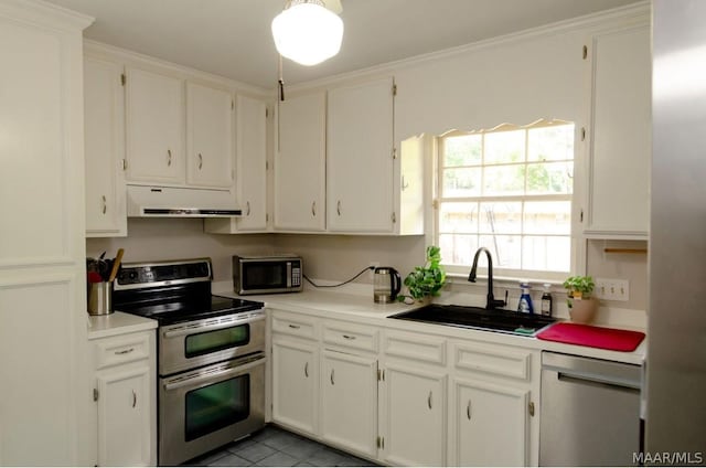 kitchen featuring a sink, stainless steel appliances, light countertops, under cabinet range hood, and white cabinetry