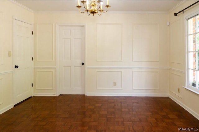 empty room featuring an inviting chandelier, crown molding, and a decorative wall