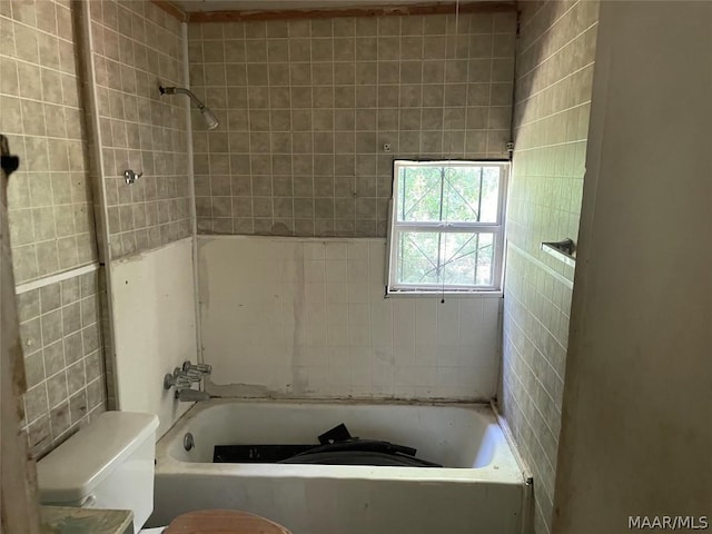 bathroom featuring tiled shower / bath and toilet