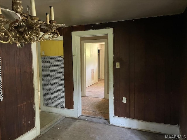 interior space featuring wood walls and a notable chandelier