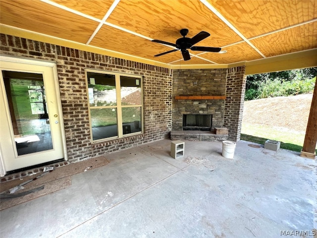 view of patio featuring an outdoor stone fireplace and ceiling fan