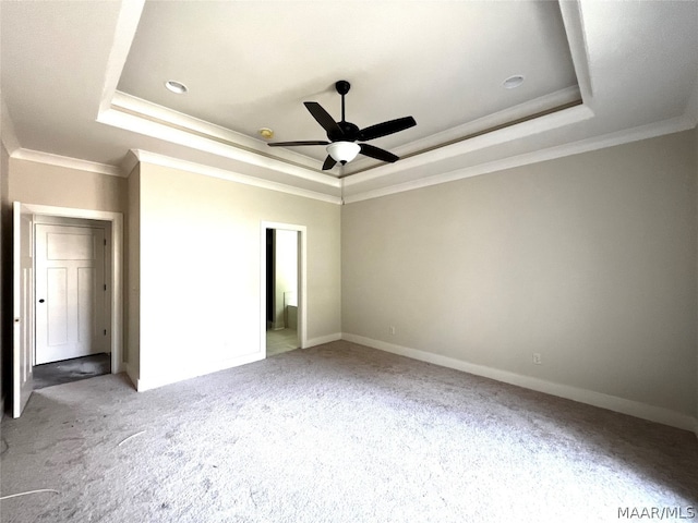 unfurnished bedroom with ornamental molding, a tray ceiling, and carpet flooring