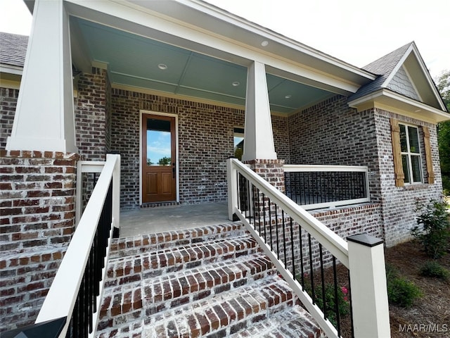 view of exterior entry featuring covered porch