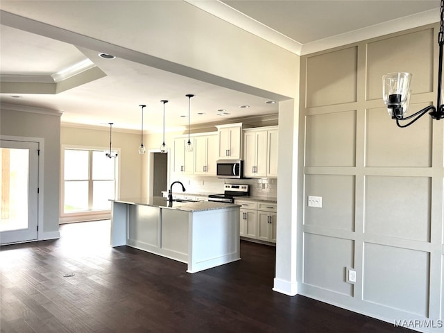 kitchen with appliances with stainless steel finishes, dark hardwood / wood-style flooring, white cabinets, and an island with sink