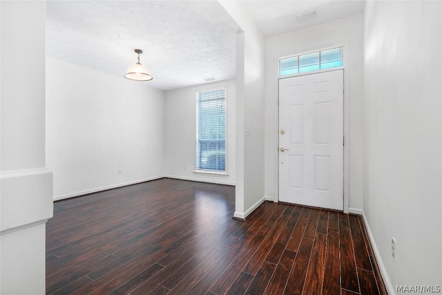 foyer entrance featuring plenty of natural light, baseboards, and dark wood-style flooring