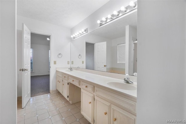 bathroom featuring tile patterned flooring, a sink, a textured ceiling, and double vanity