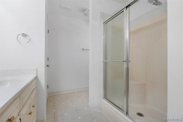 full bathroom featuring tile patterned flooring, visible vents, vanity, baseboards, and a shower with door