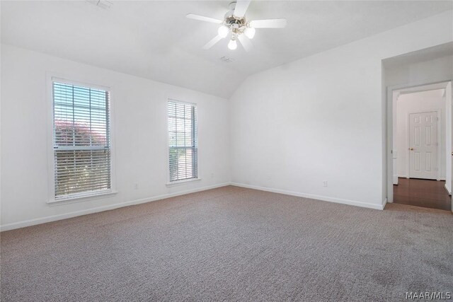 spare room featuring carpet, ceiling fan, and vaulted ceiling