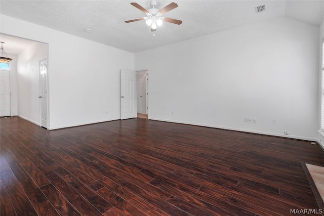 empty room with visible vents, baseboards, lofted ceiling, dark wood-style floors, and ceiling fan