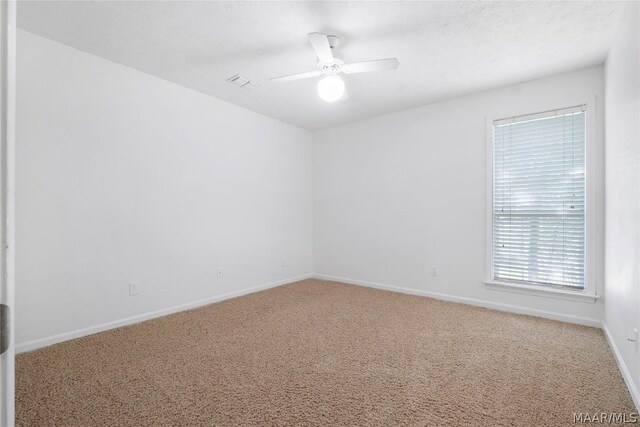 unfurnished room featuring ceiling fan and carpet floors