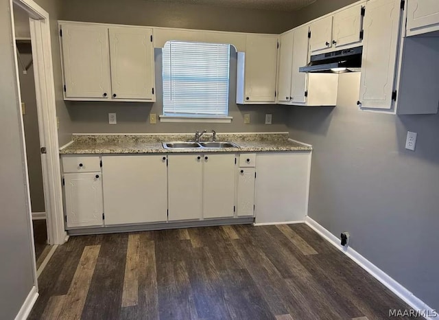 kitchen featuring dark wood-type flooring, sink, and white cabinetry