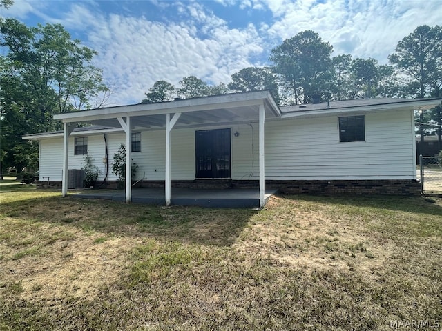 back of property featuring a patio area and a lawn