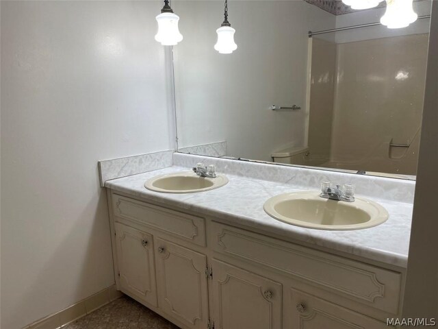 bathroom with tile patterned floors, toilet, and dual bowl vanity