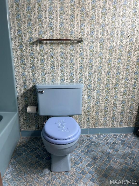 bathroom with toilet and baseboards