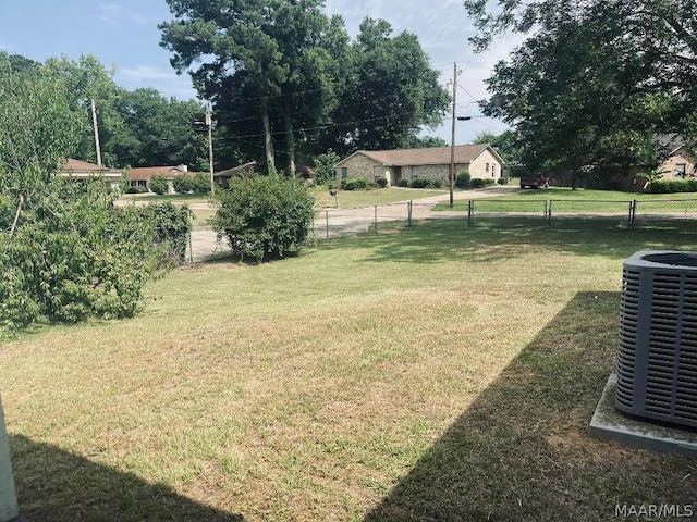 view of yard featuring fence and central AC unit