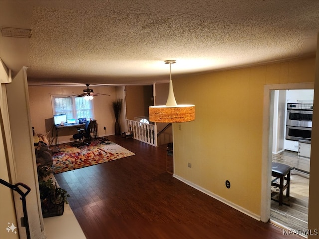 dining area with ceiling fan, dark hardwood / wood-style floors, and a textured ceiling