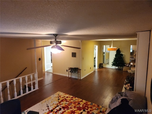 living room with ceiling fan, wood-type flooring, and a textured ceiling