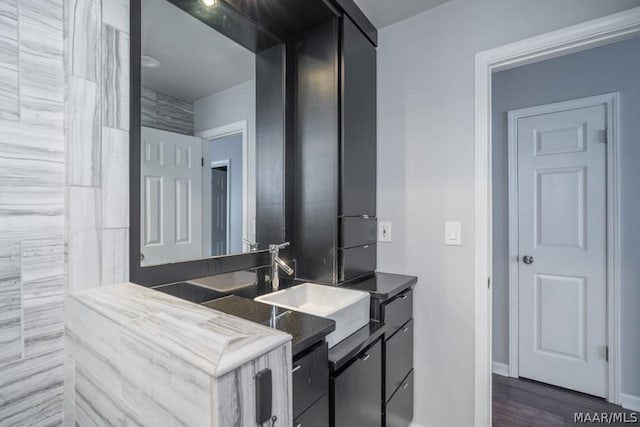 bathroom featuring vanity, baseboards, and wood finished floors