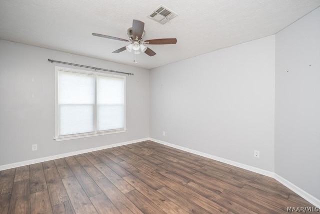 spare room featuring ceiling fan, wood finished floors, visible vents, and baseboards